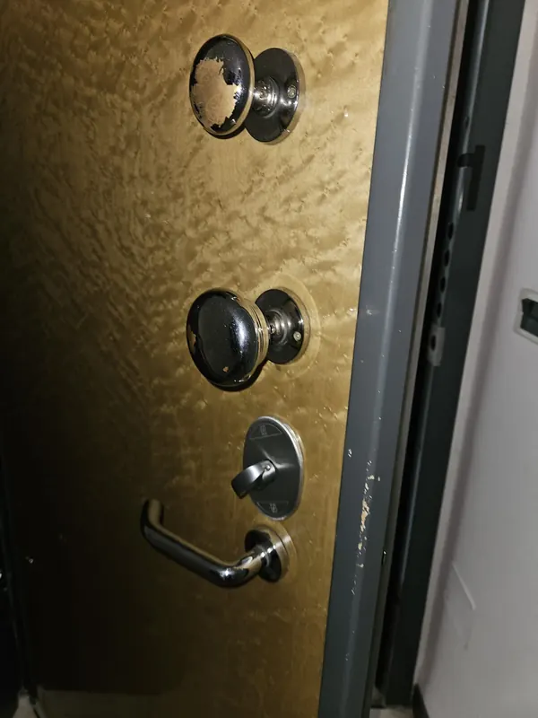 Porta blindata con defender e pomoli dopo la sostituzione della serratura a Bologna