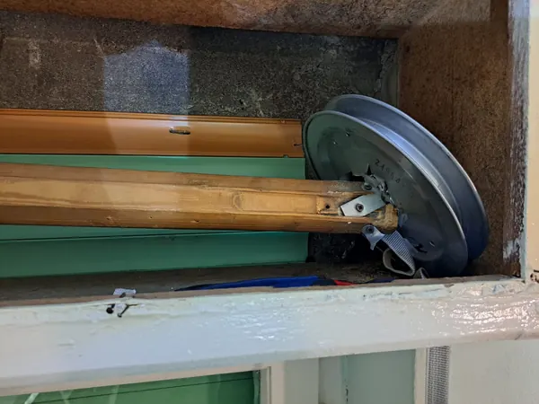Vecchio rullo in legno con puleggia rotta della tapparella, San Giorgio di Piano